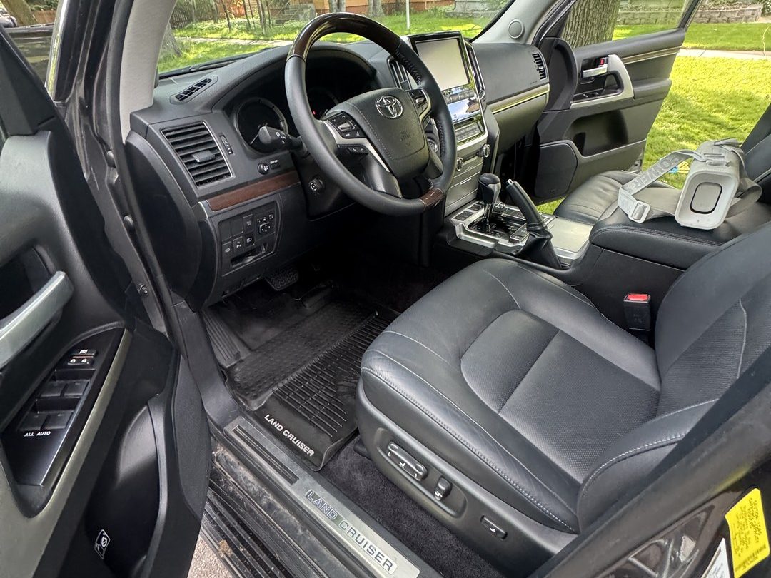Clean black leather front seats and dashboard in a Toyota Land Cruiser detailed in Missoula