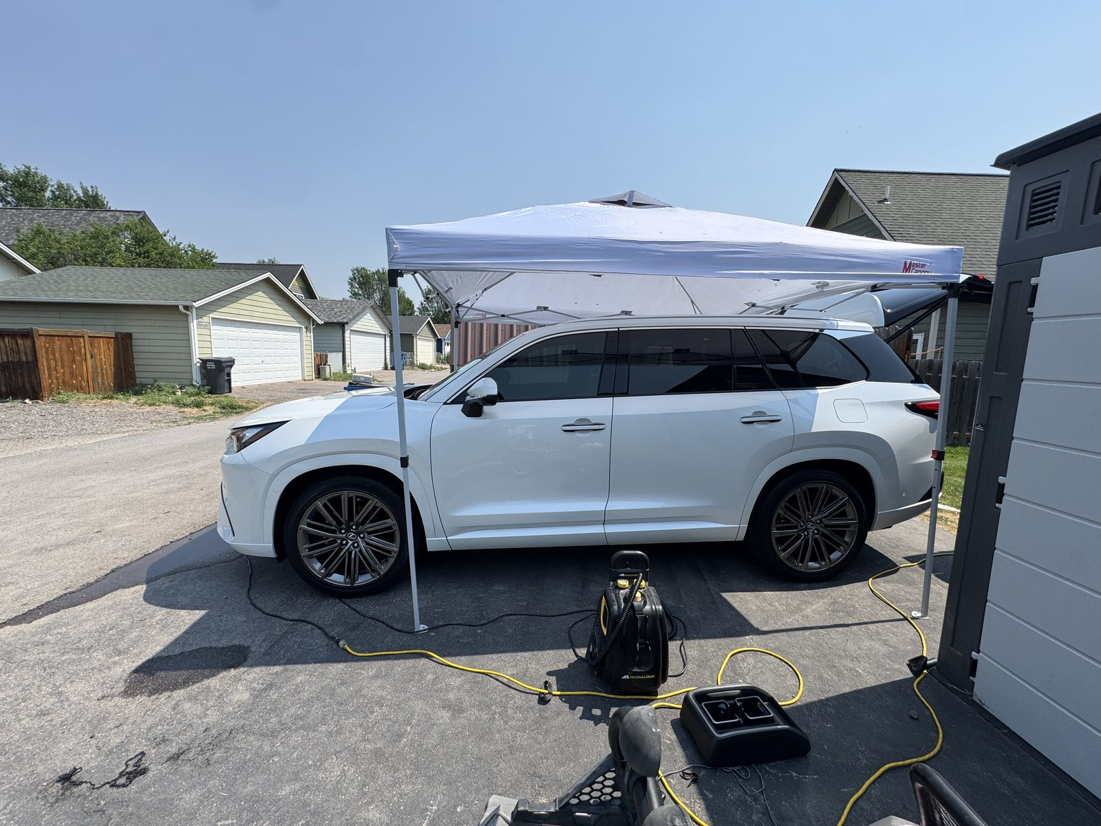 White Lexus TX side profile under canopy after a full mobile detail in Missoula