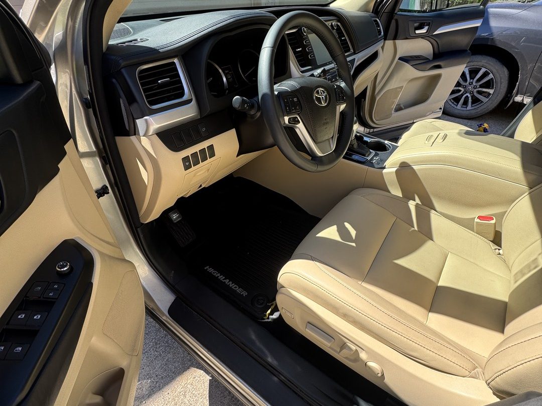 Clean tan leather front seats and dash in a Toyota Highlander detailed in Missoula